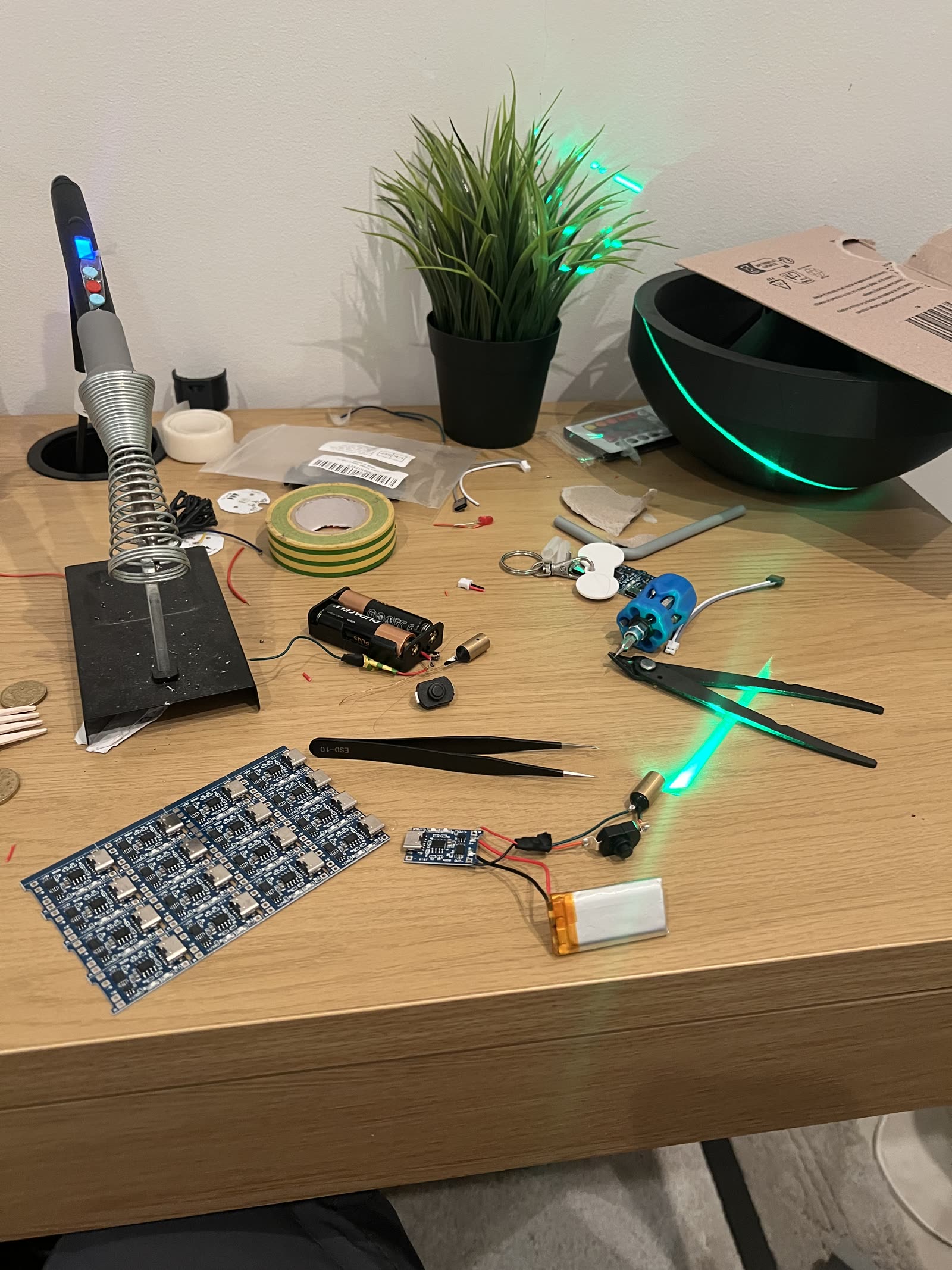 A workbench with a soldering iron, boards and components during a build