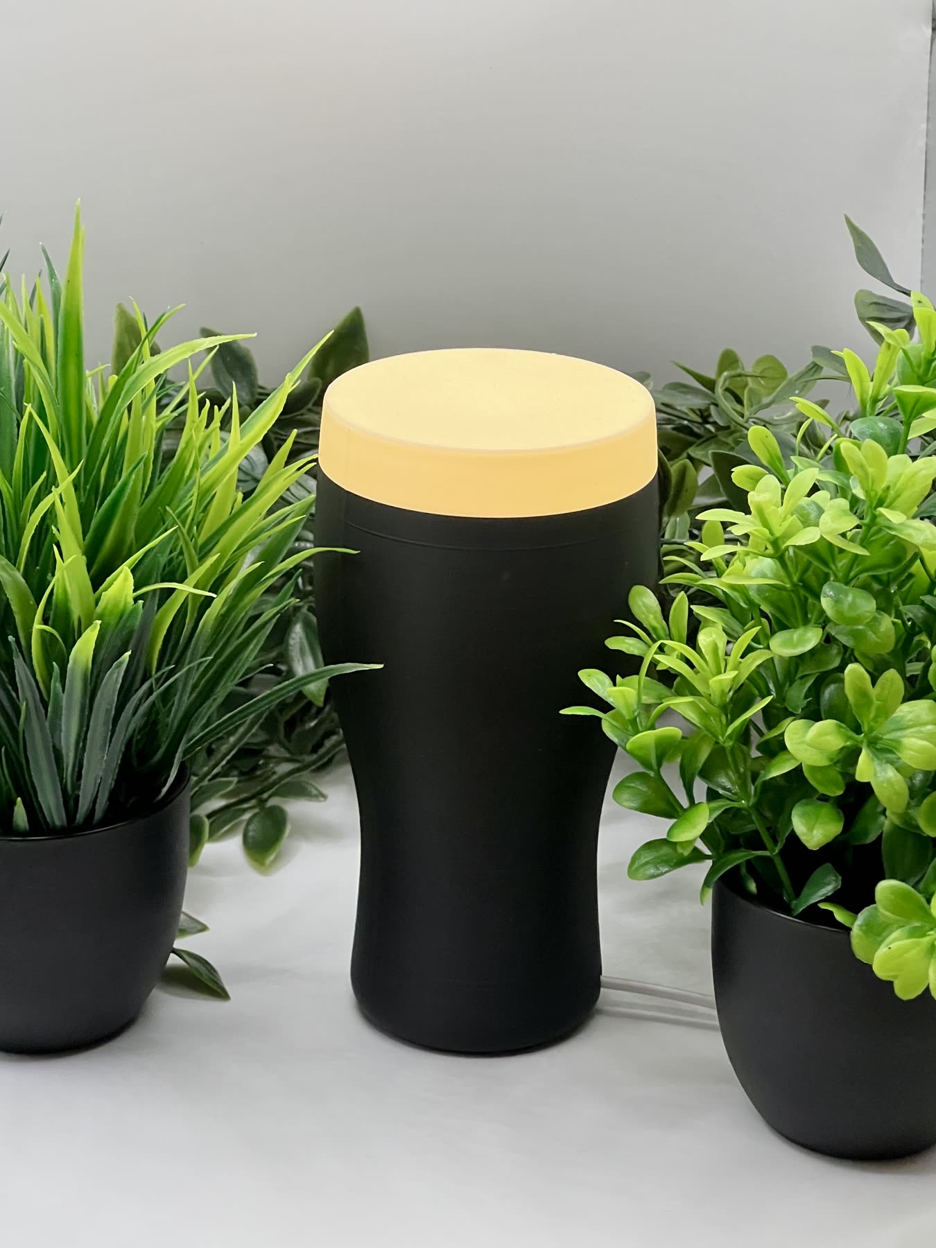 A 3D-printed pint-glass lamp lit up