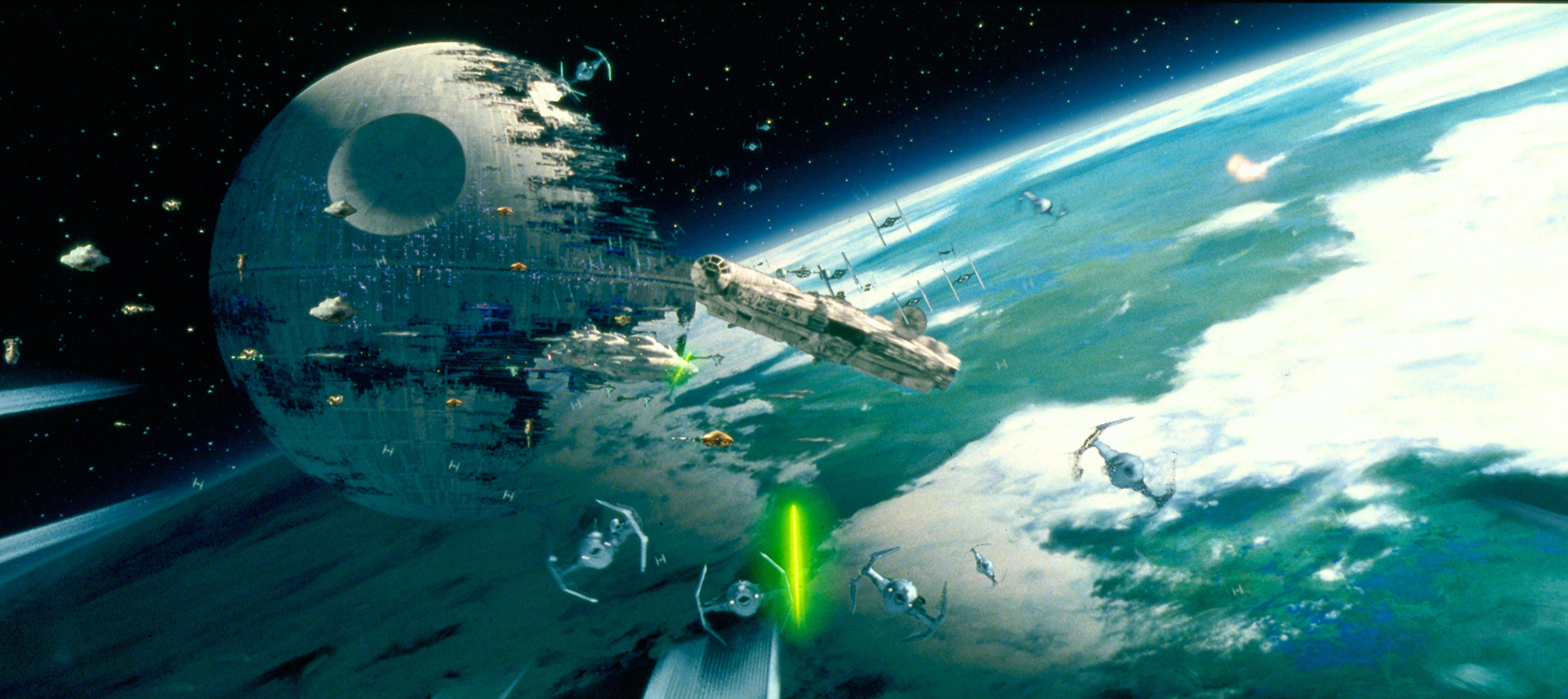 A Star Wars space battle scene with the Death Star and the Millennium Falcon above a planet