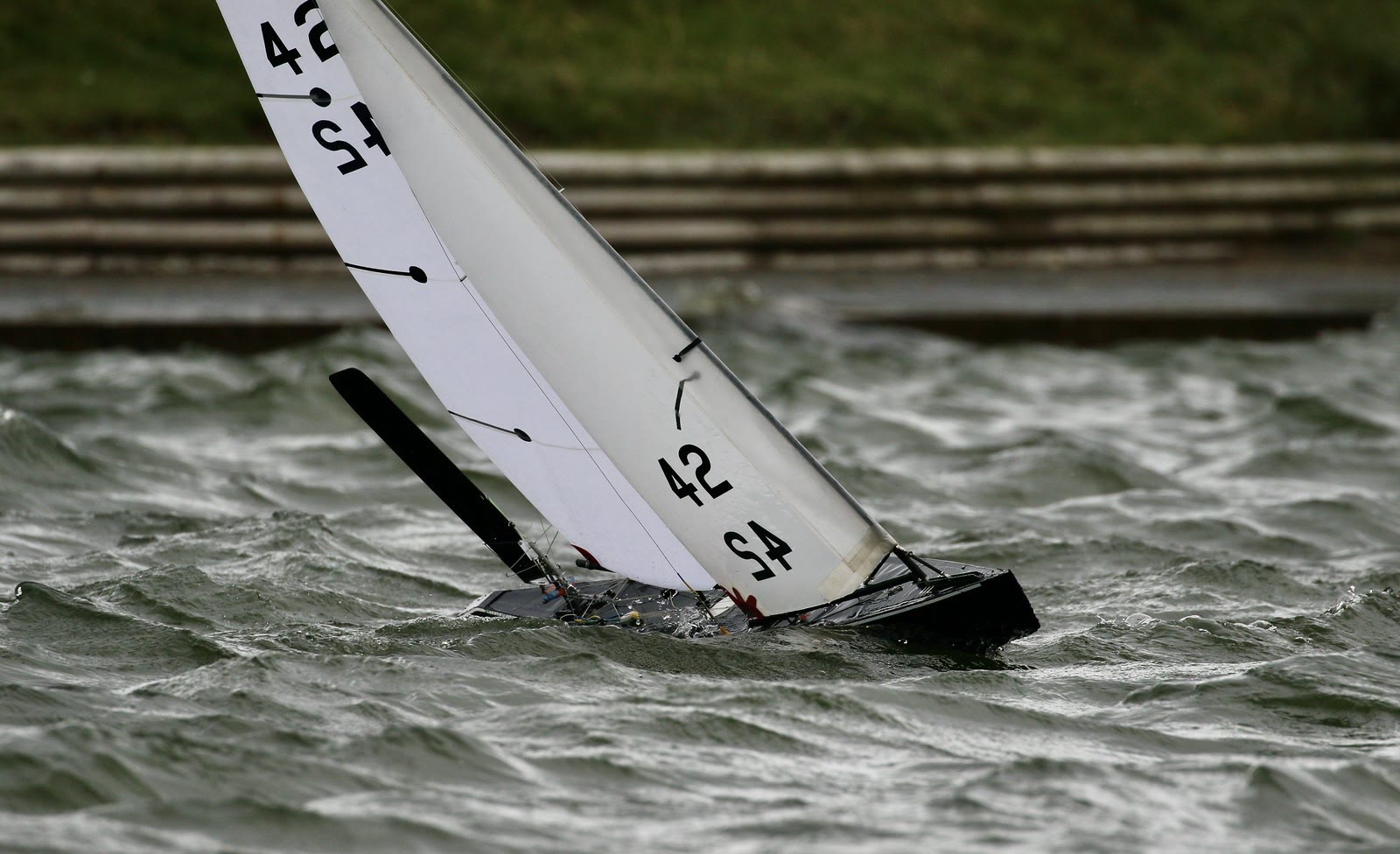 A sail drone racing through choppy water